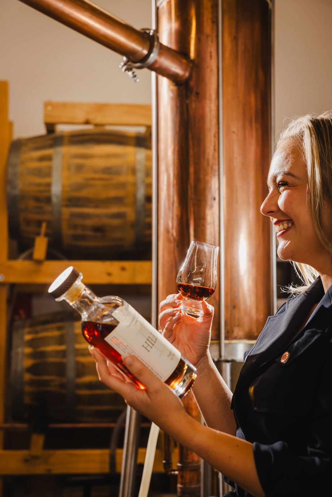 Women visiting the distillery, smiling and tasting whisky at Hillwood Distillery.